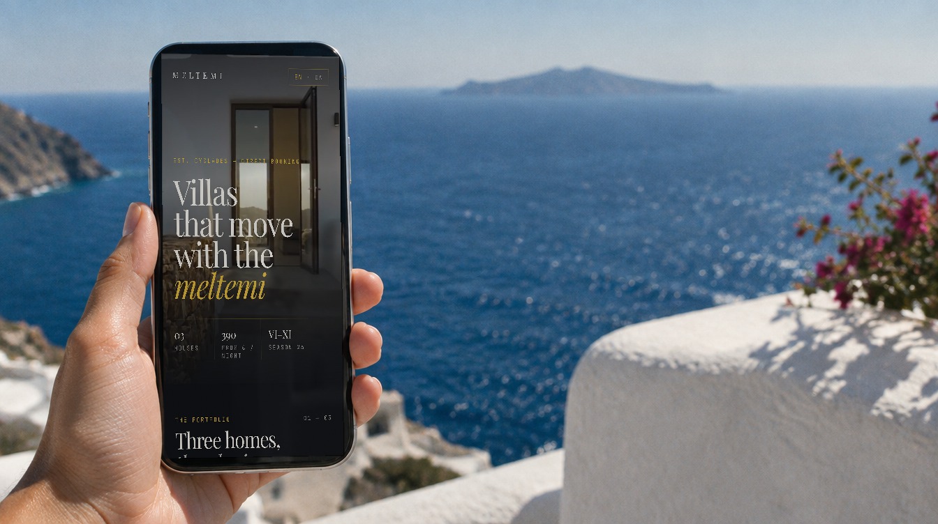 A hand holding a phone showing the Meltemi app, above the Aegean